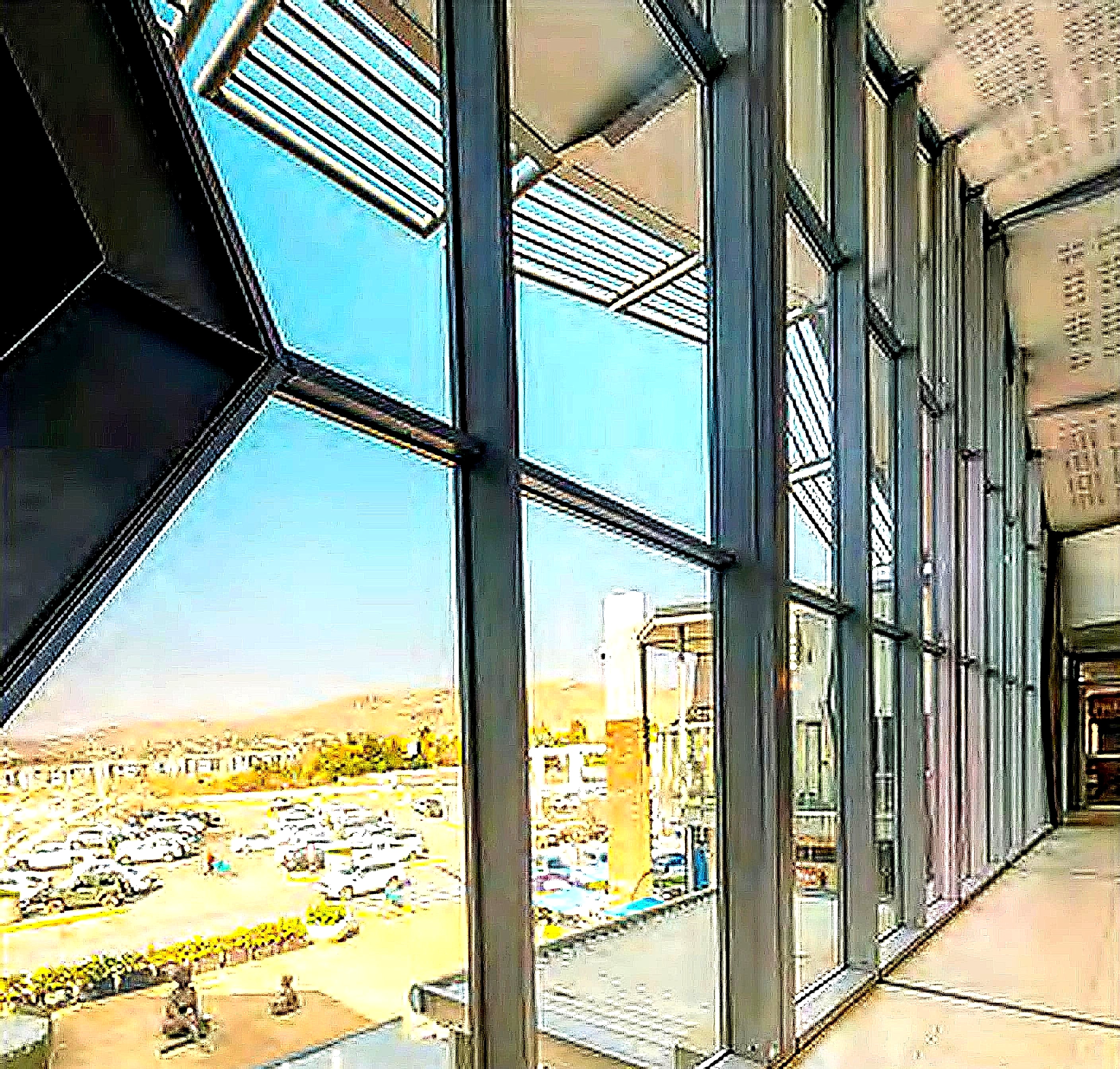 The mall interior seen through floor-to-ceiling glass, overlooking the parking deck
