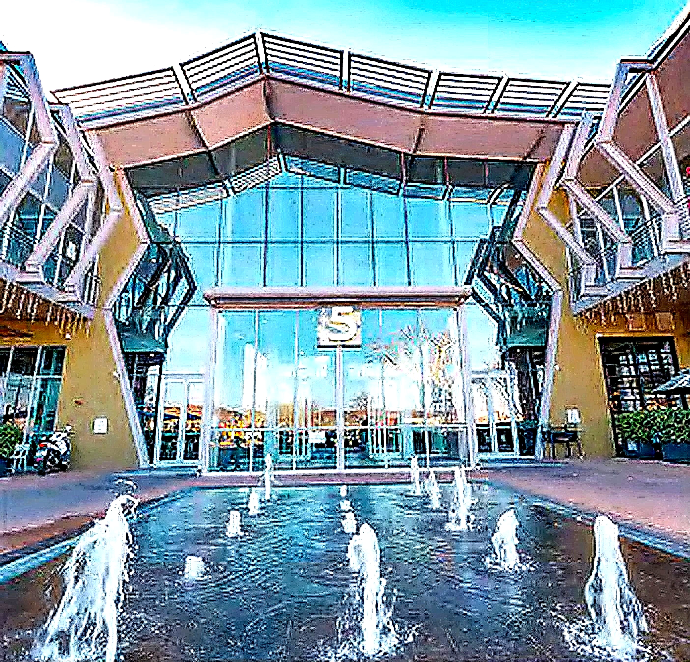 The modern glass facade entrance with the water fountain in the foreground